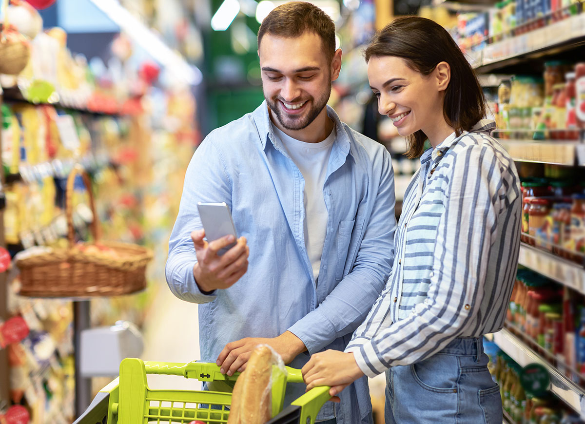 Couple shopping in grocery store using mobile technology